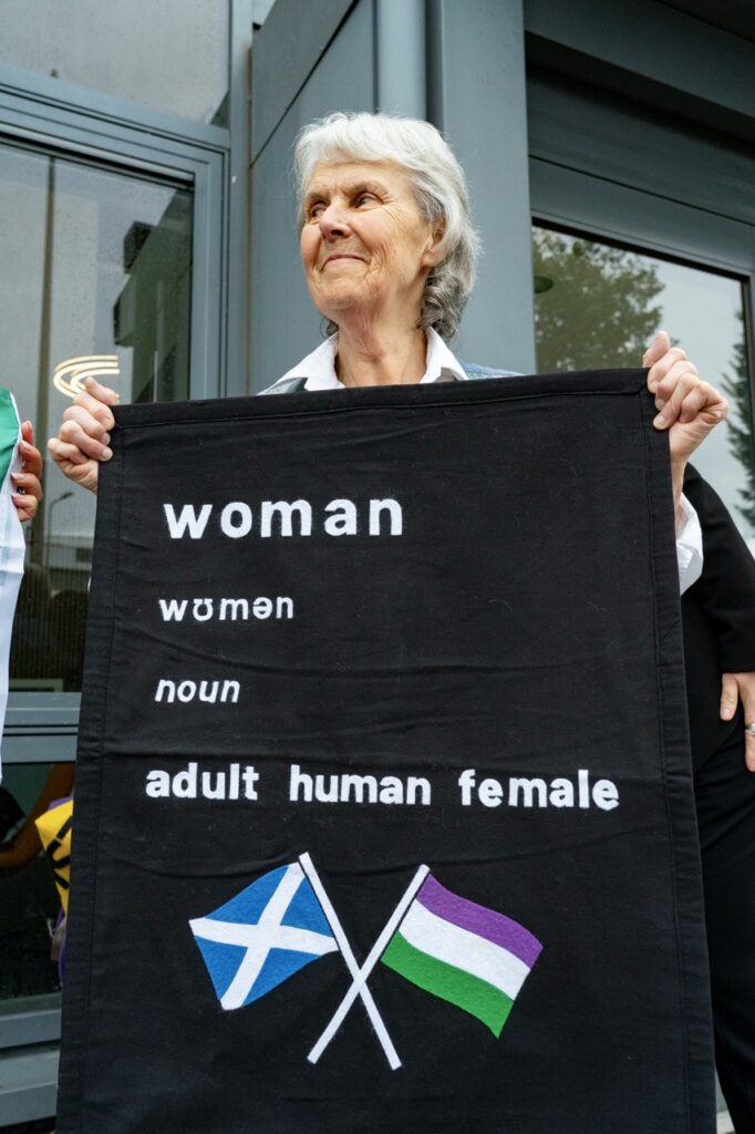 Woman holding an Adult Human Female banner
